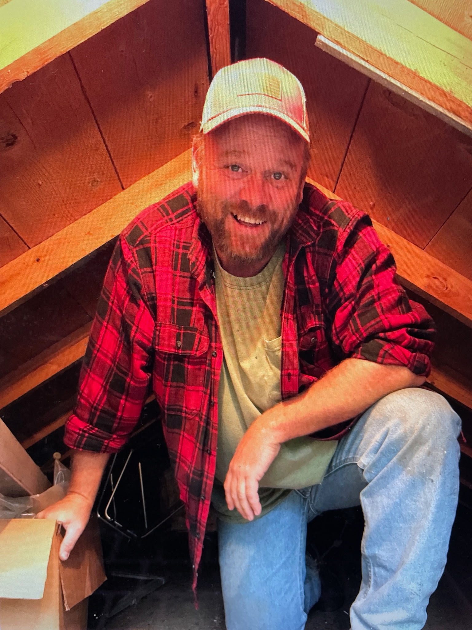 Dusty Rhoades inspecting an attic crawlspace